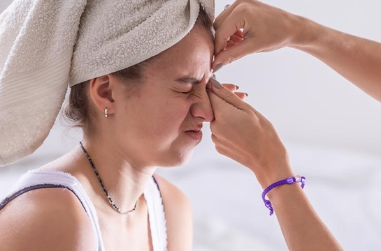  Madre exprimiendo grano del rostro de su hija.